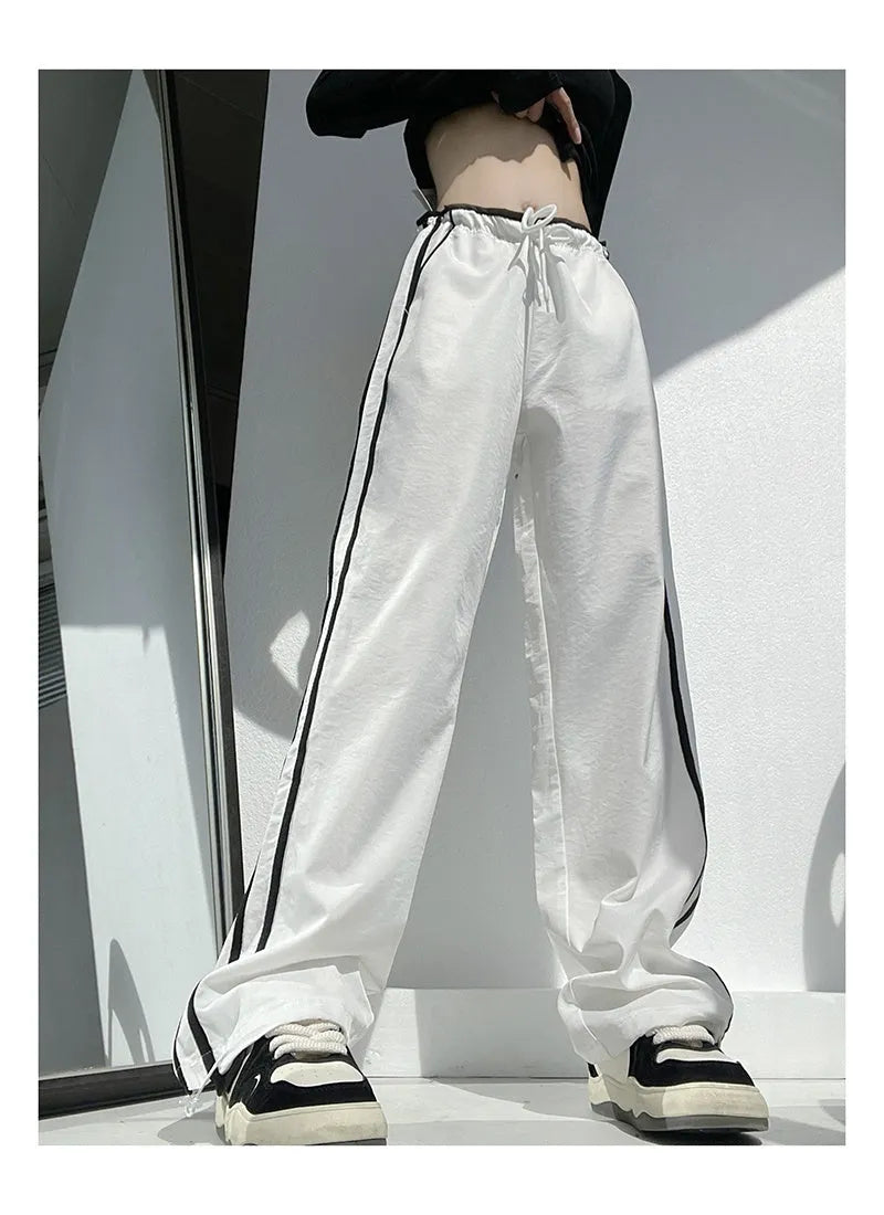 Women's loose straight leg trousers with ribbon parallel bars contrast colour detail on low waist, in thin fabric.