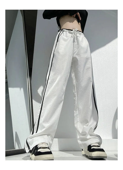 Women's loose straight leg trousers with ribbon parallel bars contrast colour detail on low waist, in thin fabric.