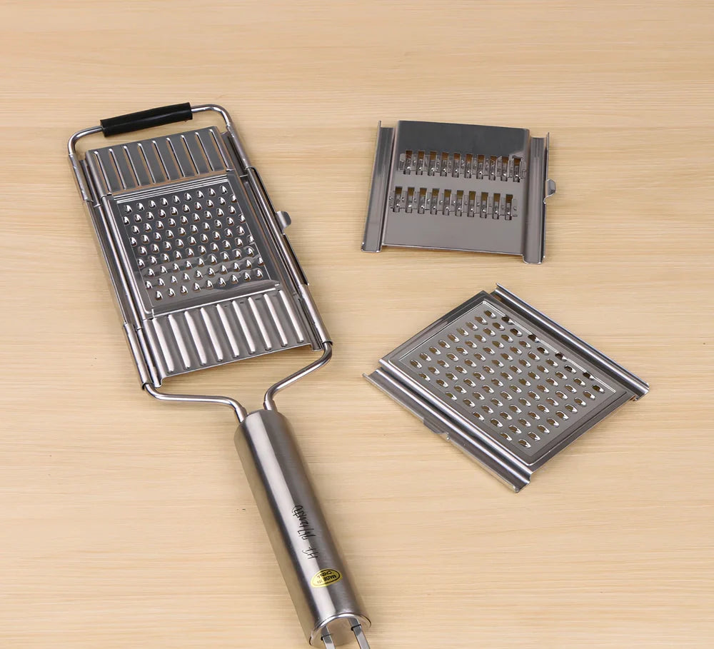 Green mandolin chopper with hand guard, food container, and three blades for safe vegetable slicing