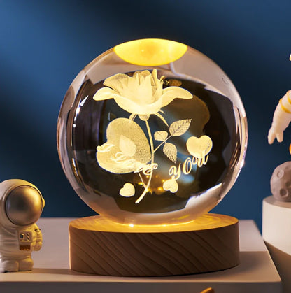 3D crystal ball night light projecting solar system pattern on wooden base with astronaut figurine