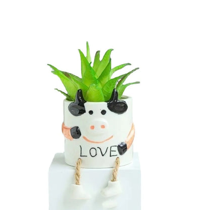 Ceramic hanging foot flowerpot for succulent plants with cartoon styling on desktop