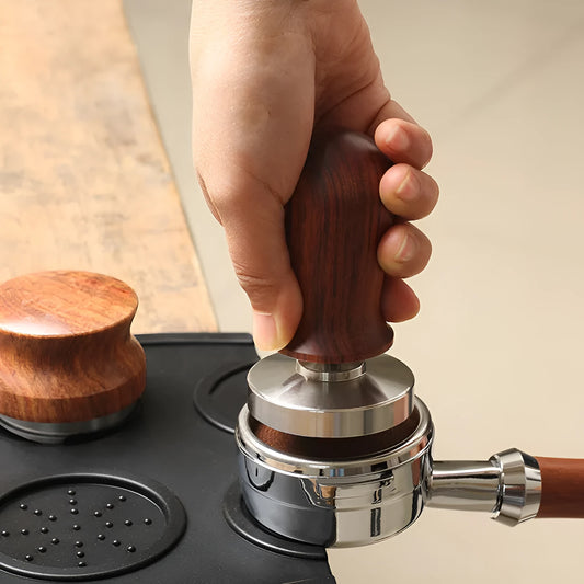 Stainless steel coffee tamper with silicone distribution pad in black or red, showing aluminium handle.