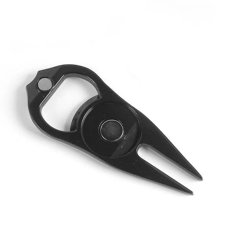 A black zinc alloy golf ball yoke tool with a bottle opener and a separate ball coin on a putting green.