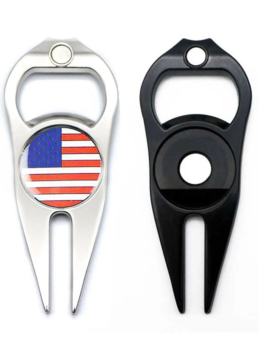 A black zinc alloy golf ball yoke tool with a bottle opener and a separate ball coin on a putting green.