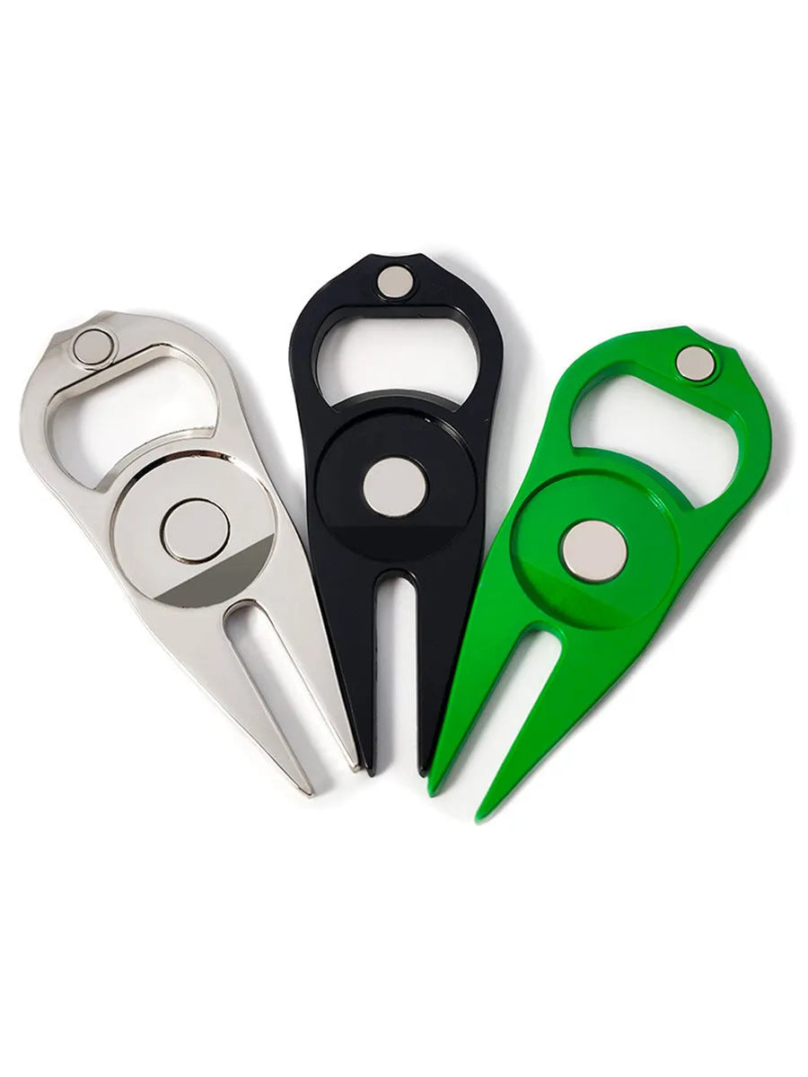 A black zinc alloy golf ball yoke tool with a bottle opener and a separate ball coin on a putting green.