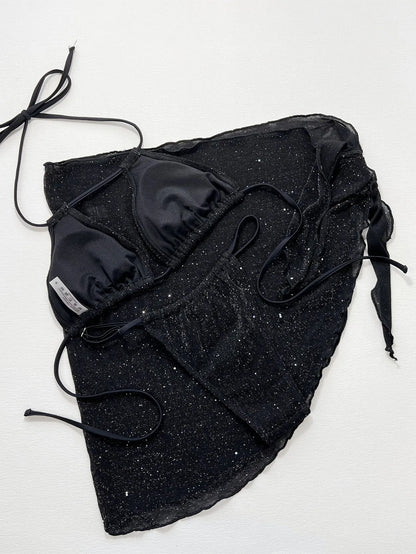 Black three-piece swimsuit bikini set with a top and shorts laid flat.