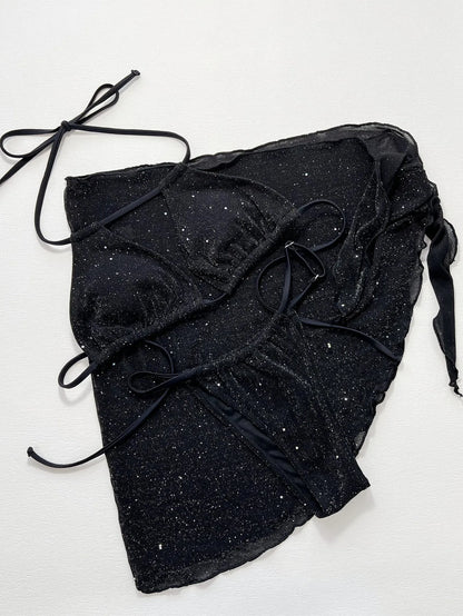 Black three-piece swimsuit bikini set with a top and shorts laid flat.