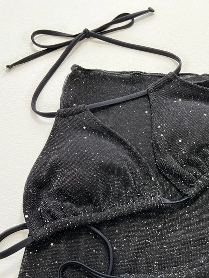 Black three-piece swimsuit bikini set with a top and shorts laid flat.
