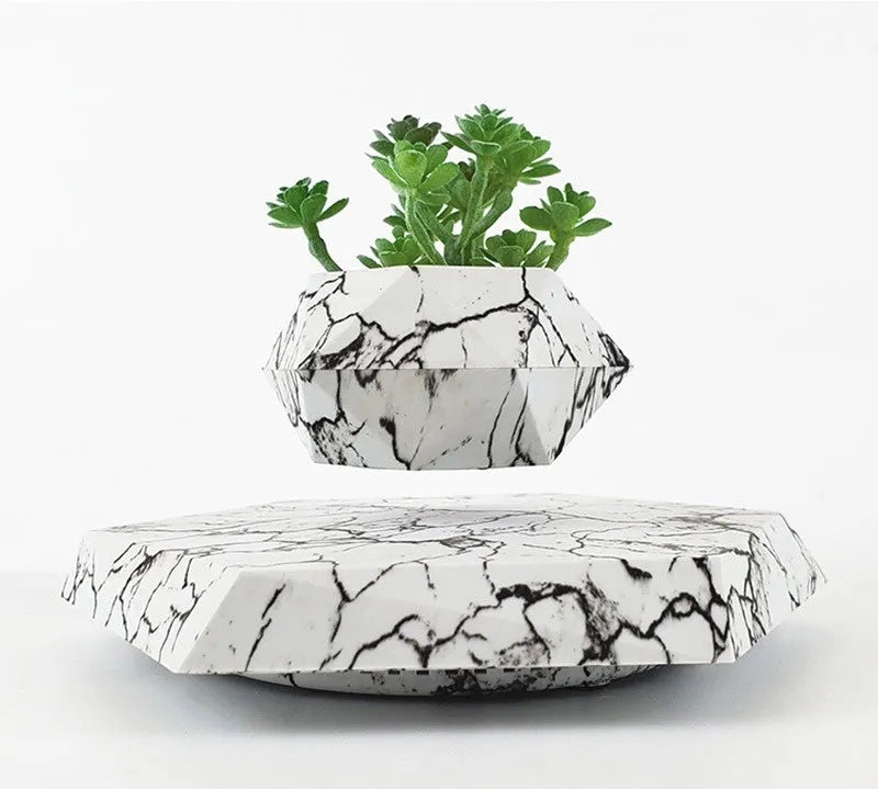 Marbling colour magnetic levitating plant pot floating above base with small plant inside