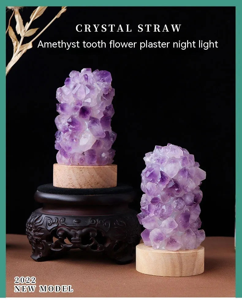 Miniature amethyst crystal tooth flower night light glowing with warm light on a wooden surface.