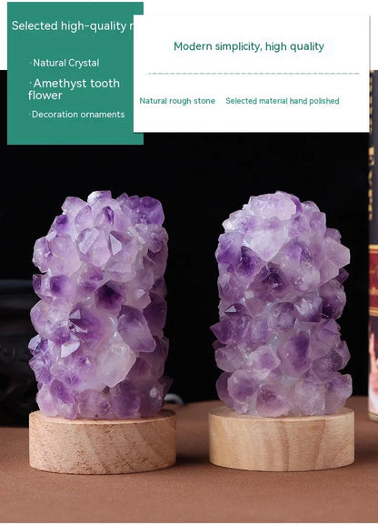 Miniature amethyst crystal tooth flower night light glowing with warm light on a wooden surface.