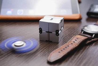 Zinc alloy Infinity Cube with eight rotating cubes showing black and silver colour options on wooden surface