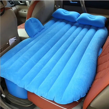 Black inflatable car bed with flocked surface and two pillows, shown folded into a chair inside a vehicle.