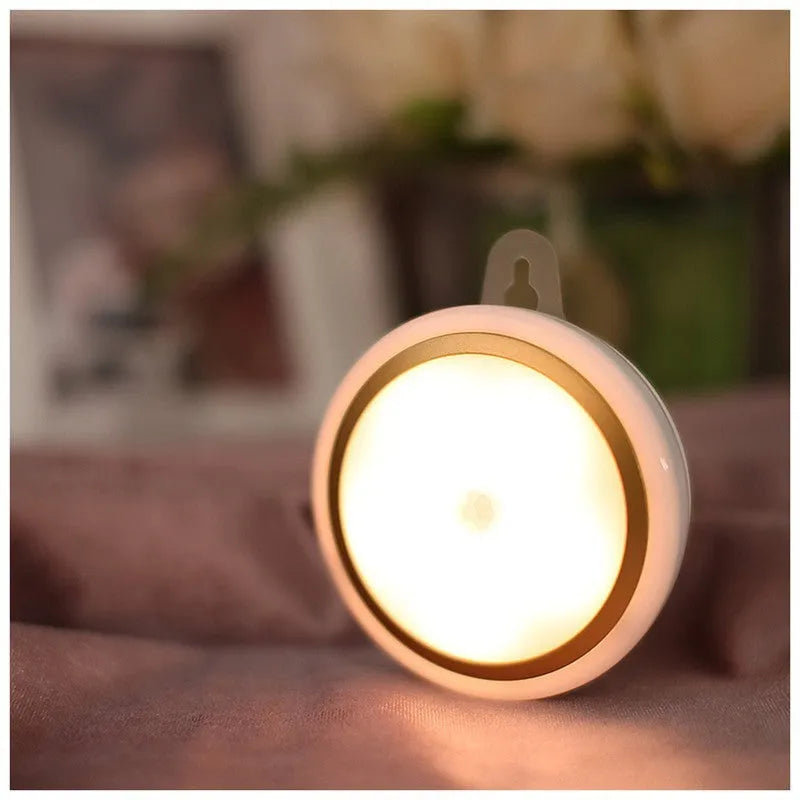 A round, white, battery-powered motion sensor LED light with a diameter of 80mm.