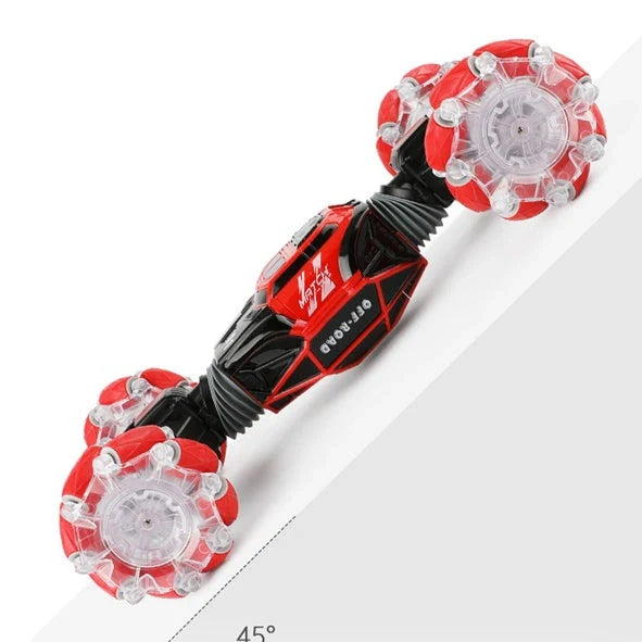 Red 4WD RC stunt car performing sideways drift with LED lights illuminated, showing gesture remote control
