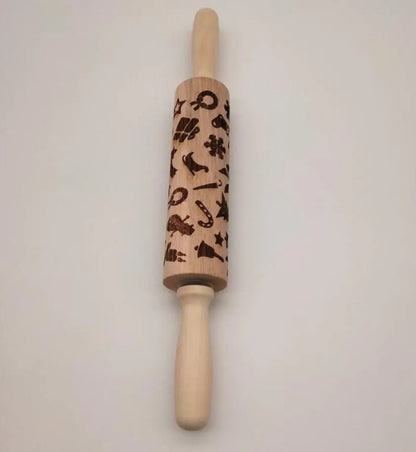 Wooden rolling pin with engraved Christmas patterns including reindeer and snowflakes on a 45cm long barrel.