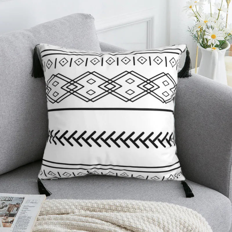 Bohemian style decorative pillowcase in light grey colour on a sofa.