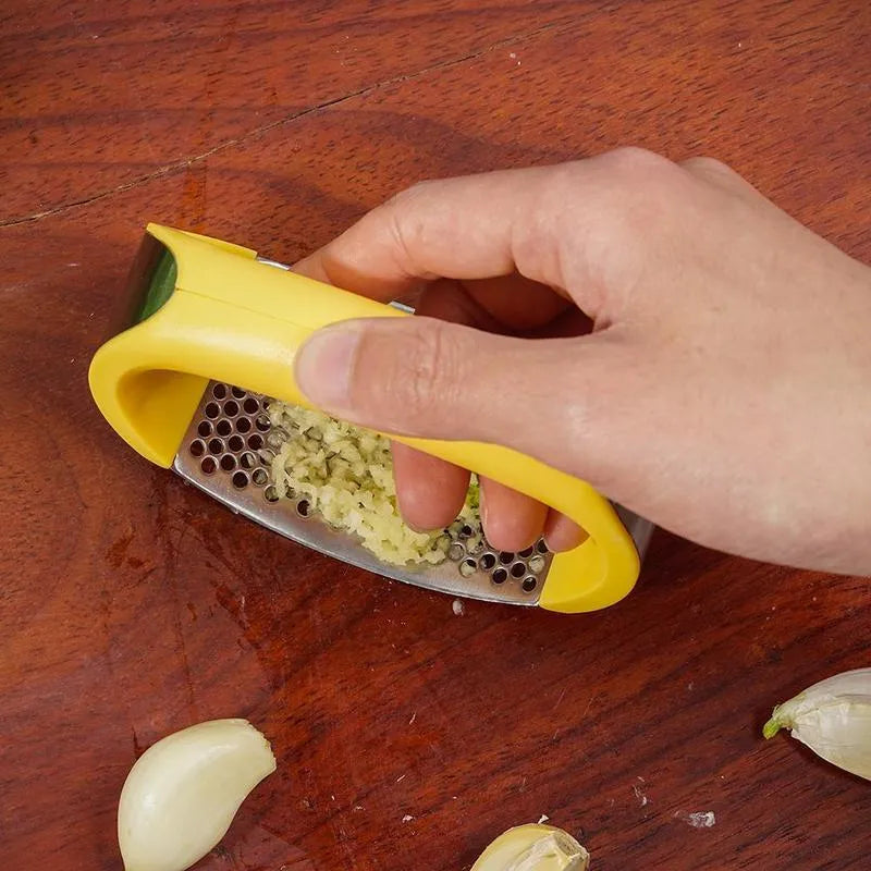 Stainless steel garlic press with ergonomic handle in kitchen setting