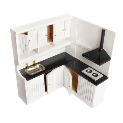 White two-piece dollhouse kitchen cabinet set with sink and stove units on a table.