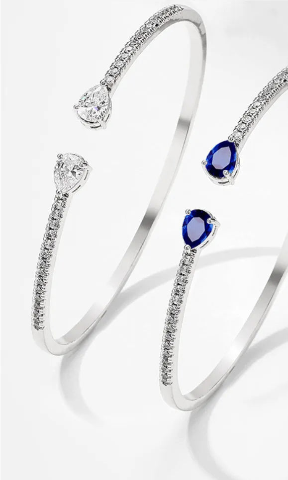 Close-up of a multi-zircon inlay fashion bracelet in copper, shown in blue and white colour options.
