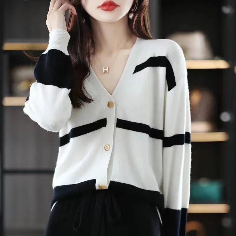 Women's black and white striped V-neck cardigan with buttons, showing a textured 3D knit pattern.