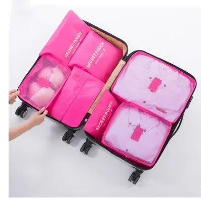 Set of six coloured nylon packing cubes and flat pouches for travel organisation.
