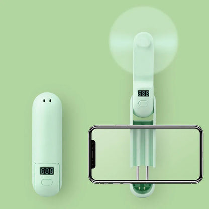 Green folding mini fan with plastic leaves in open position showing compact USB-rechargeable design