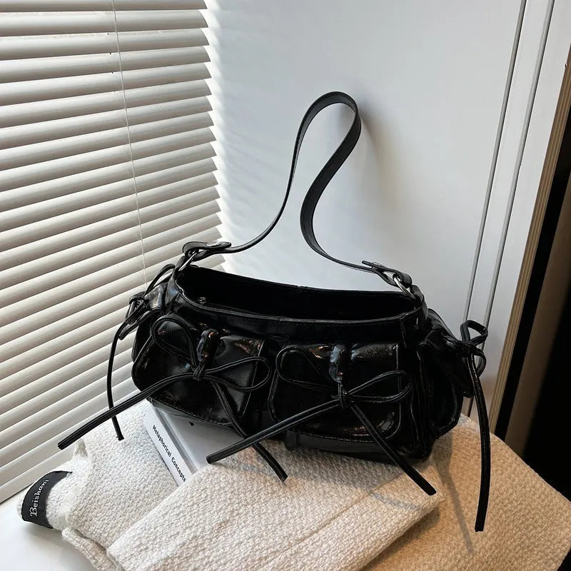 Women's tassel bow shoulder bag in pleated design with multiple pockets, shown in a selected colour.