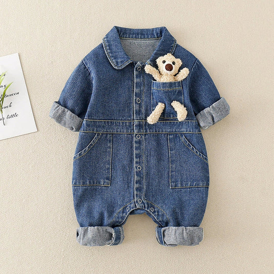 Baby boy wearing blue denim jumpsuit with single-breasted closure, holding matching teddy bear accessory