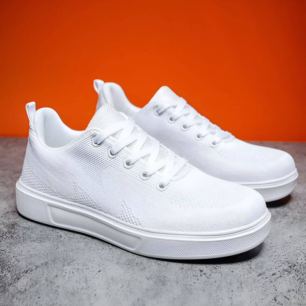 Pair of light white thick-soled casual sneakers with mesh upper and lace-up front.