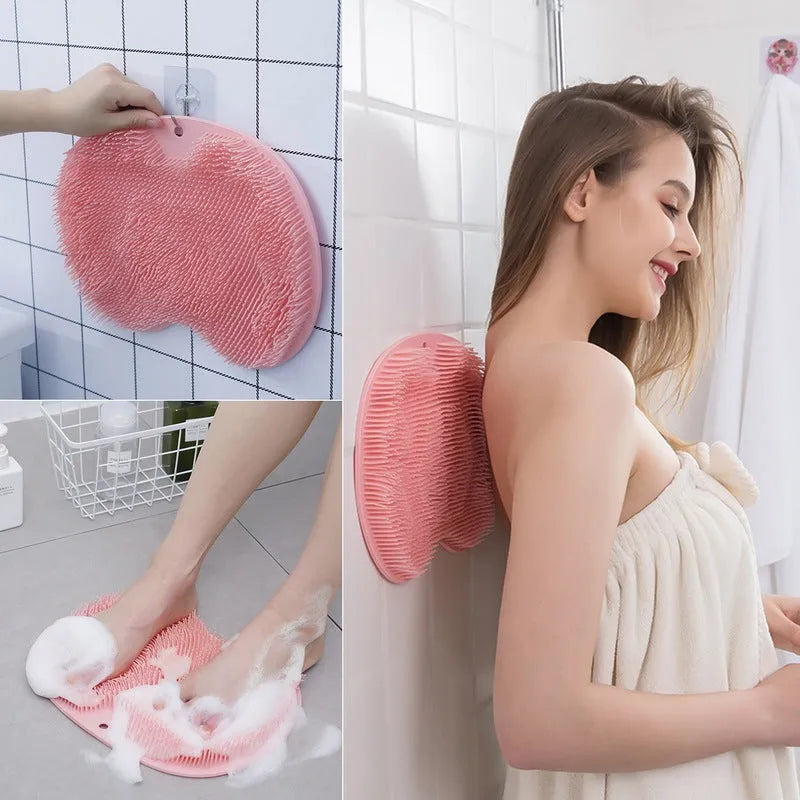 Orange non-slip massage bath brush with silicone bristles and suction cup base on shower floor