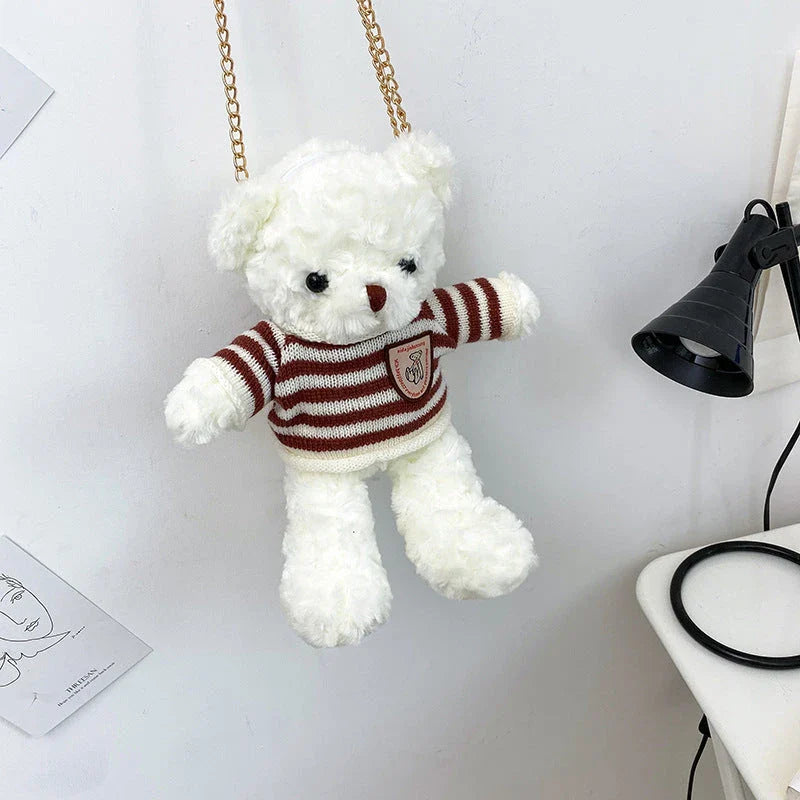 A plush teddy bear crossbody messenger bag with an adjustable shoulder strap and a zippered interior pocket for convenient storage.