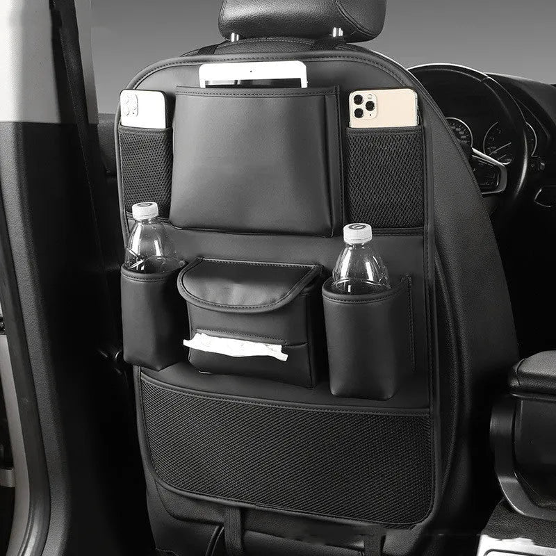 Black leather car seat back storage bag with multiple pockets, hanging behind a car headrest.