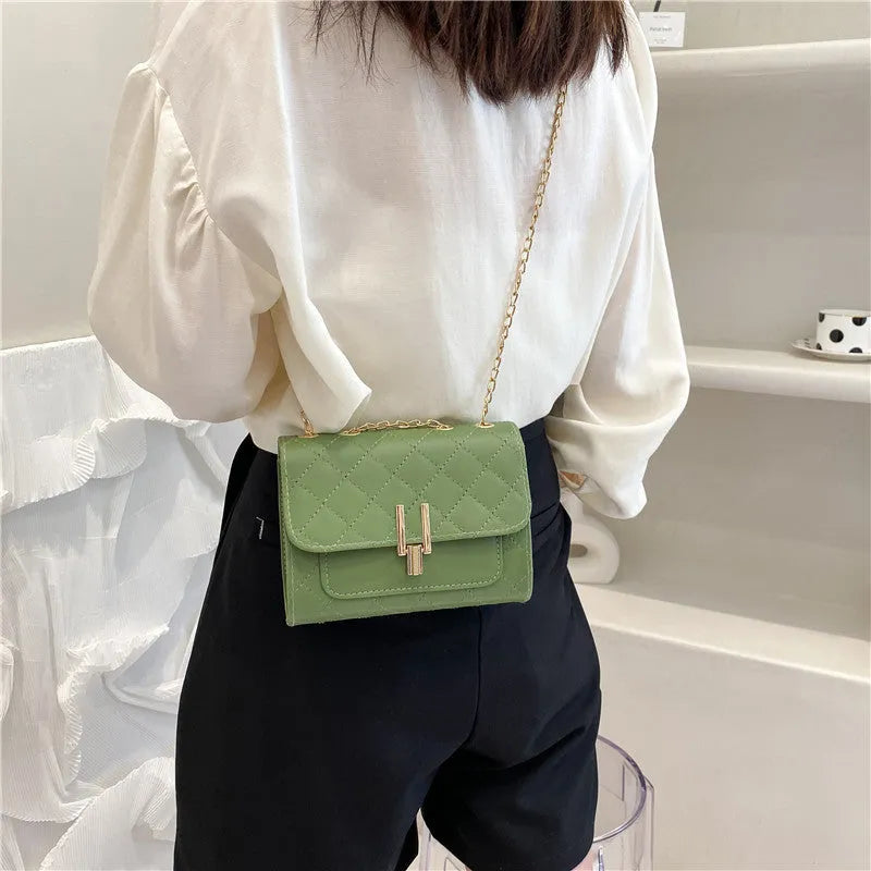 Women's solid colour PU leather crossbody bag with diamond lattice chain strap in black, green, or white.