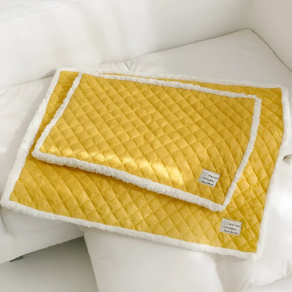 Quilted terry cloth pet blanket for cats in blue, grey, pink, or yellow colour on a pet bed.