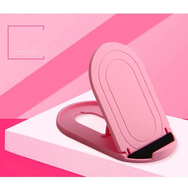Black adjustable lazy bracket phone stand holding a mobile device at an angle on a wooden table.