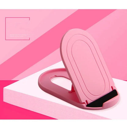 Black adjustable lazy bracket phone stand holding a mobile device at an angle on a wooden table.