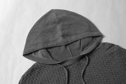 Man wearing a cotton-polyester blend hooded sweatshirt in grey, showing the front design and hood.