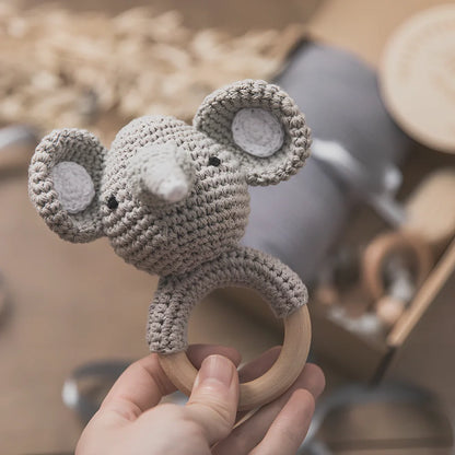 Six wooden animal bath toys floating in water with blue, brown and peach colour options