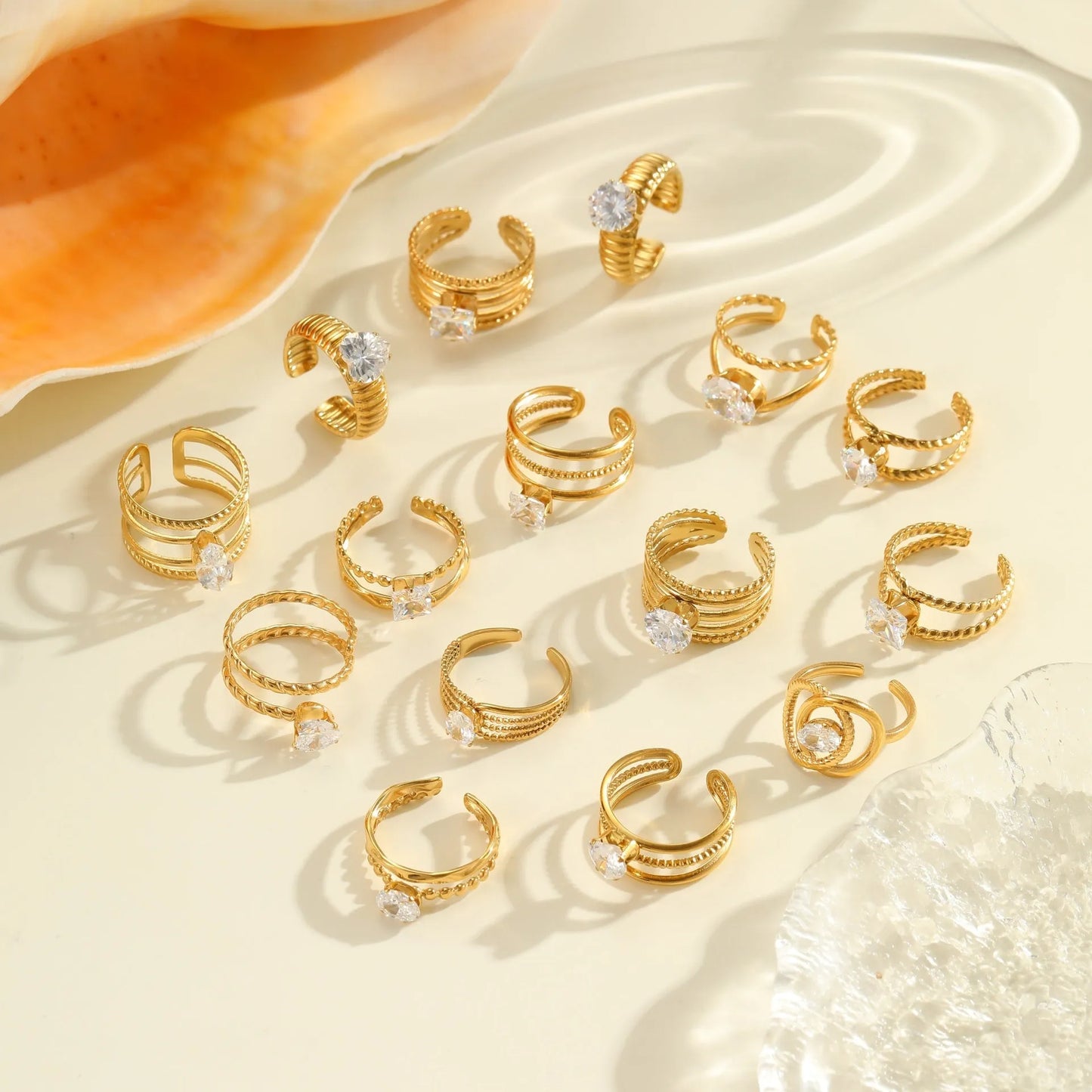 Gold electroplated stainless steel open mouth ring with geometric shapes and zircon inlay on a heart drop.