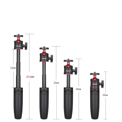 Compact black red and white phone tripod selfie stick stand extended next to a mobile phone.