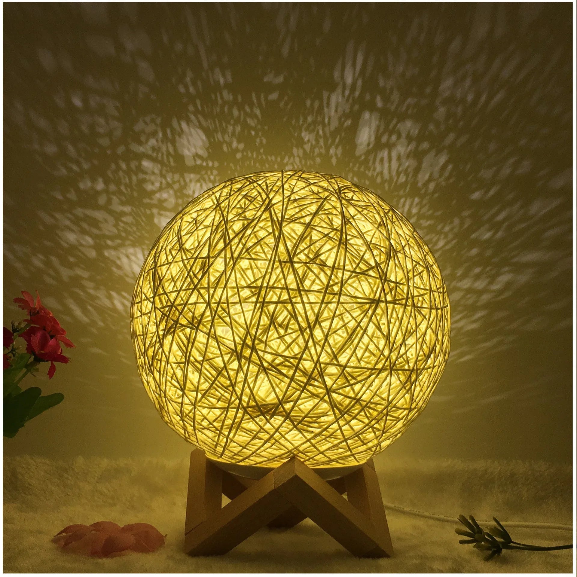 Spherical hand-knitted rattan table lamp with remote control on a wooden desk