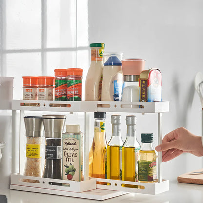 Pull-out spice rack installed under kitchen sink with spices organised in plastic drawer