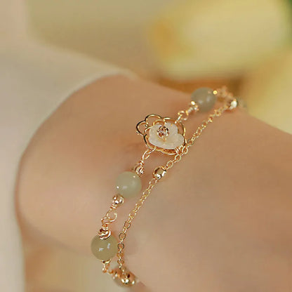 Women's shell flower butterfly bracelet in yellow gold with geometric design and hetian jade style charm.