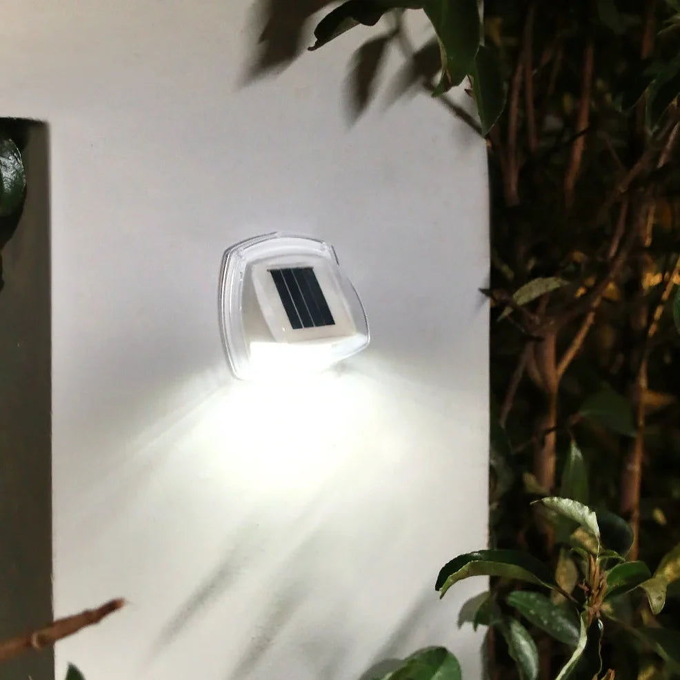 Solar garden wall lamp with waterproof housing mounted on brick wall