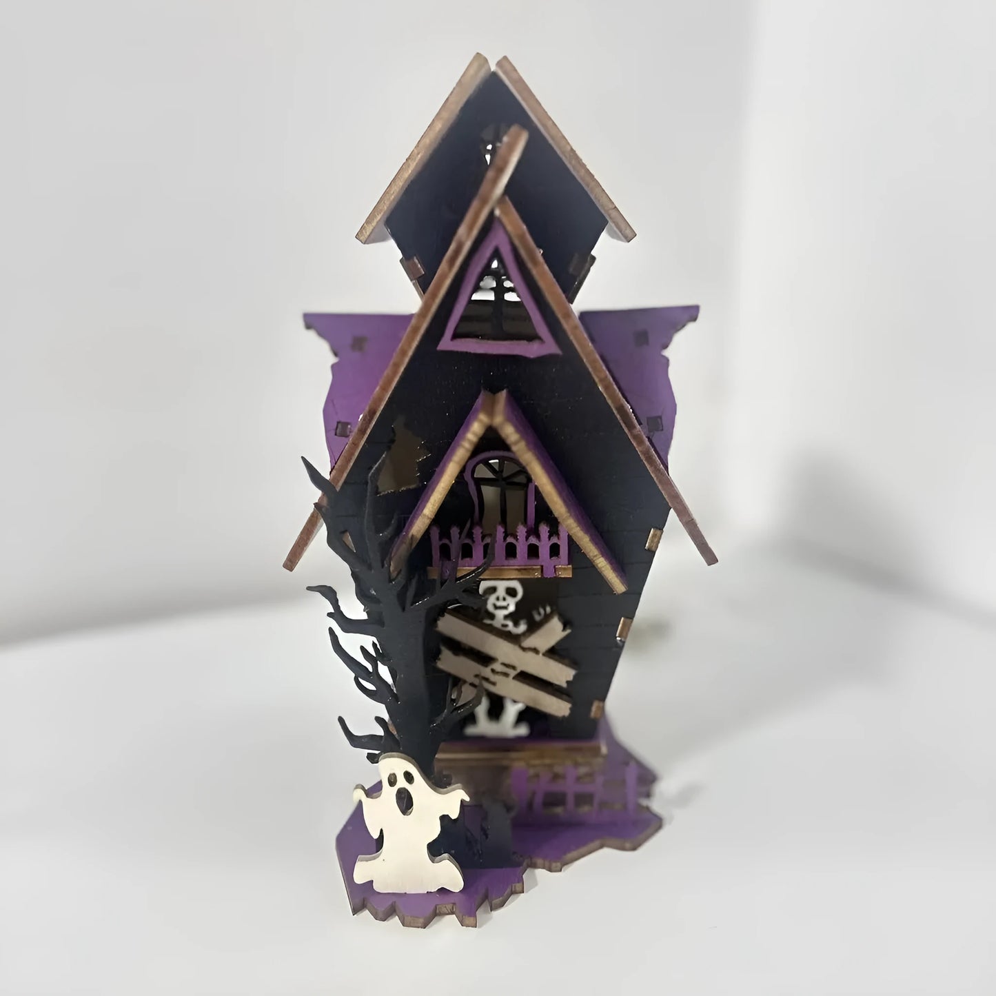 Wooden haunted house table decoration measuring 14x10.5x19cm with luminous finish and candlestick holder function