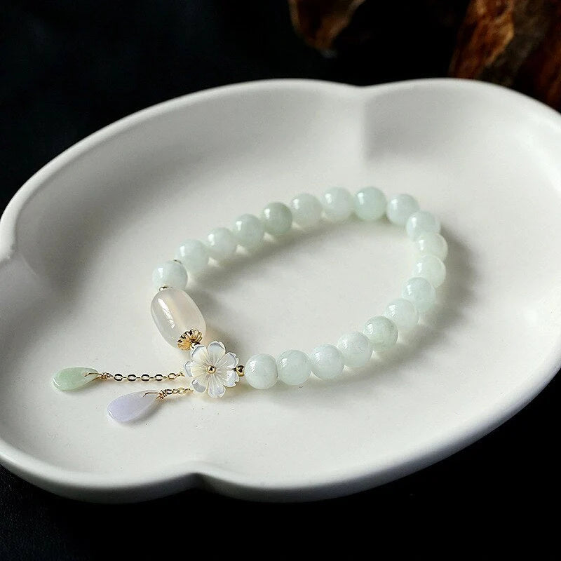 Elegant jade and shell bracelet with geometric design, featuring natural jadeite, apple agate, and genuine shells accented by 14K gold fittings