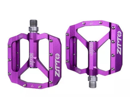 Aluminum alloy bicycle pedal with chrome molybdenum steel shaft in black, red, silver, and purple