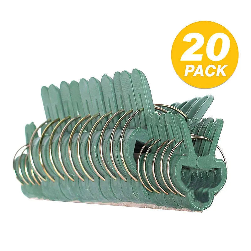 Green plastic plant fixing clips, large and small sizes, holding a tomato stem to a garden cane.