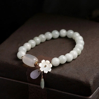 Elegant jade and shell bracelet with geometric design, featuring natural jadeite, apple agate, and genuine shells accented by 14K gold fittings